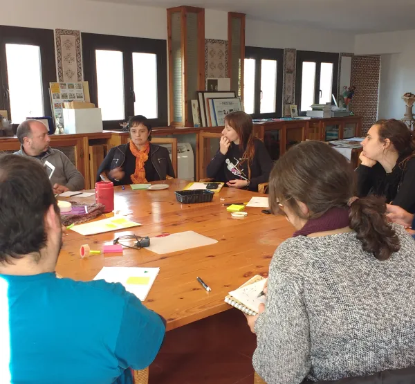 Imatge persones assegudes al voltant d'una taula fent formació